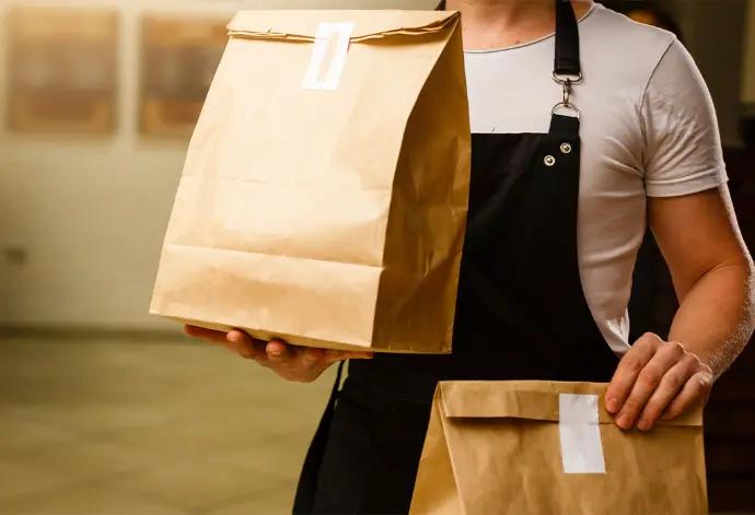 Livraison de repas en entreprise en sacs kraft par un traiteur