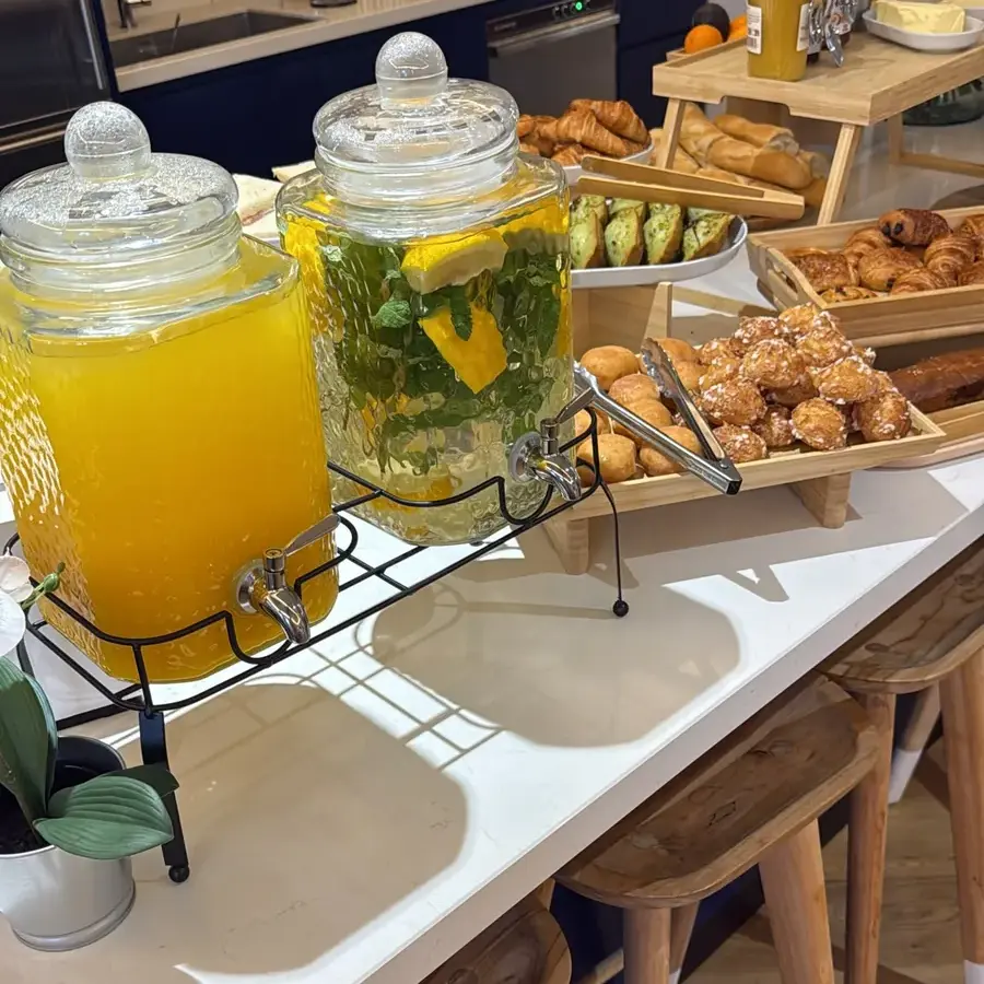Carafes de jus d’orange et d’eau infusée au citron et à la menthe, avec viennoiseries
