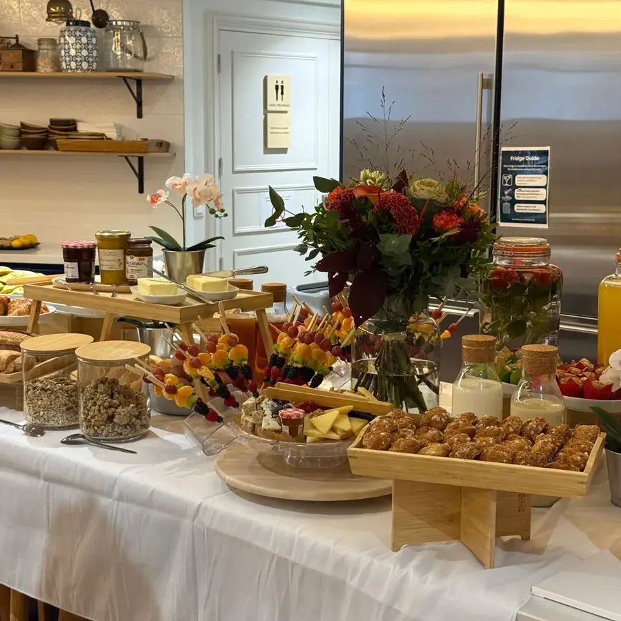 Buffet de petit-déjeuner avec pots de toppings Yogurt Kitchen, brochettes de fruits et viennoiseries