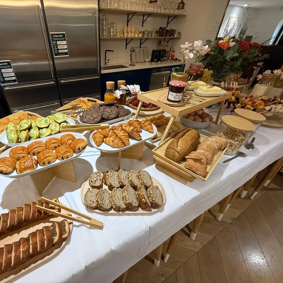 Viennoiseries, pains et cakes tranchés sur la table d’un petit-déjeuner d’entreprise